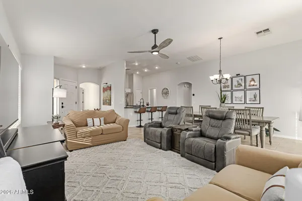 a living room with furniture kitchen view and a chandelier