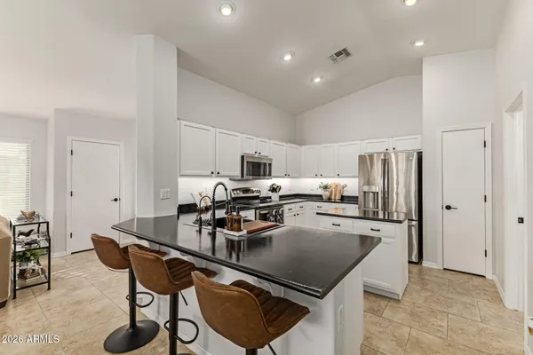 a kitchen with a table chairs refrigerator and cabinets