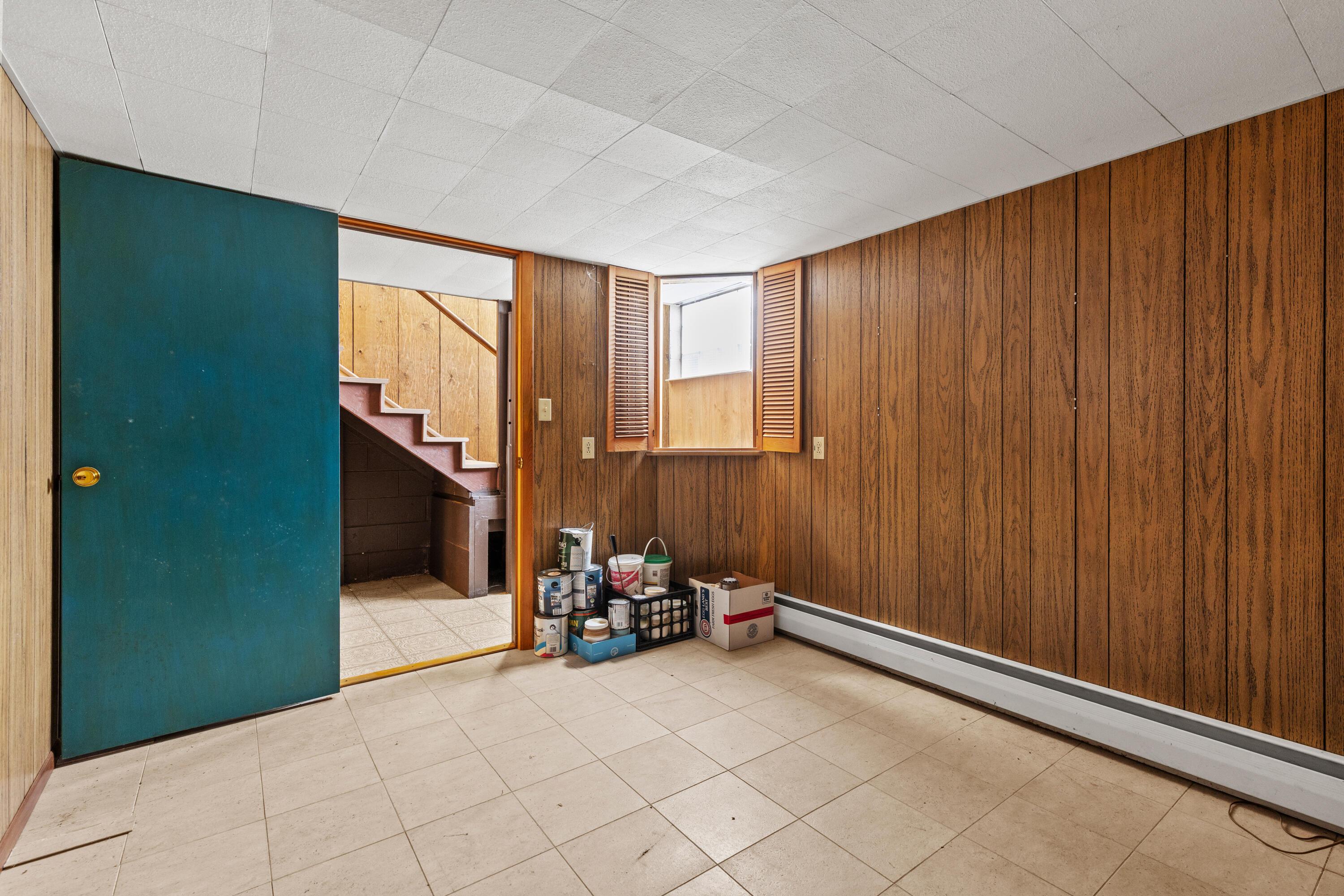 6982 Lee Road Westerville, OH 43081 - Photo 44 of 71 • Neutral vinyl flooring • Paneled walls • Built-in book shelves • Acoustic ceiling tiles