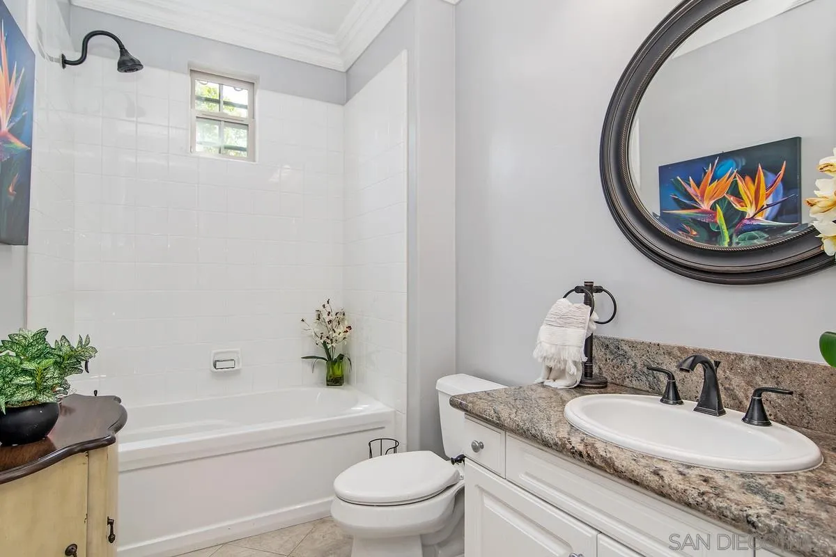 2080 Historic Decatur Road San Diego, CA 92106 - Photo 17 of 47 a bathroom with a granite countertop toilet a sink and a mirror