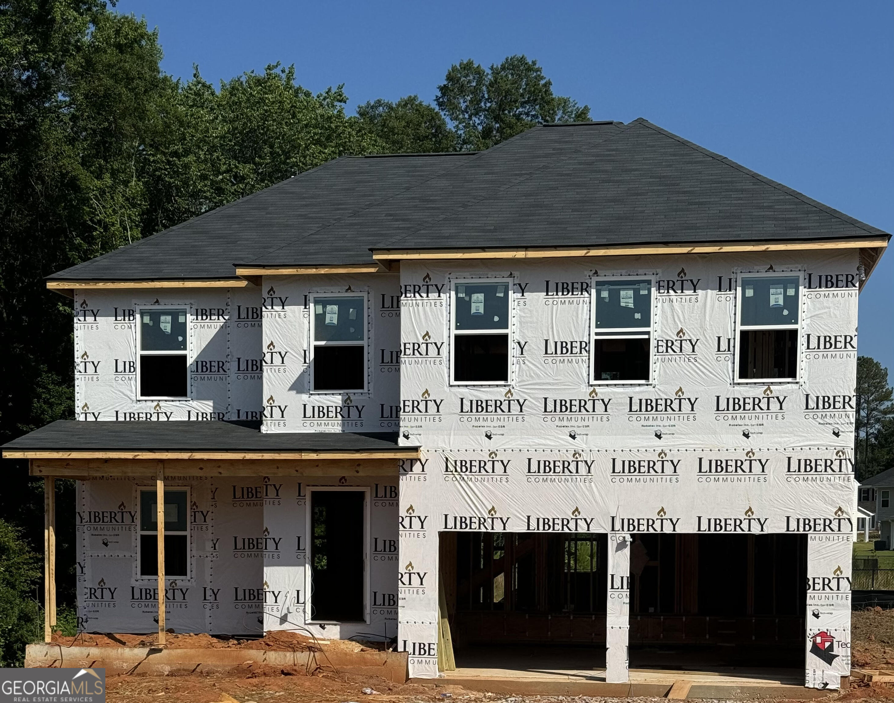 a view of a white building with large windows and palm tree