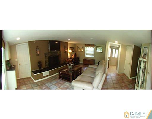 92 George Avenue Edison, NJ 08820 - Photo 2 of 15 a living room with furniture a flat screen tv and a fireplace