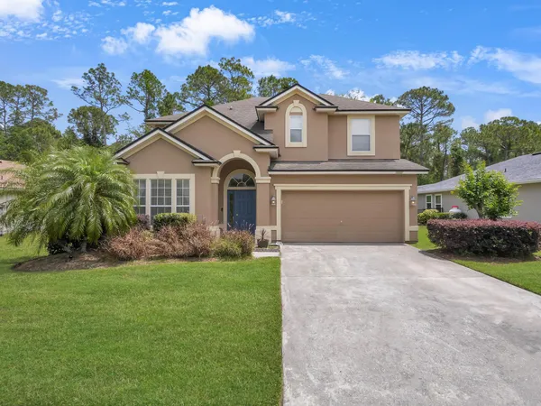 a front view of a house with a yard and garage