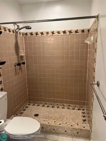 a bathroom with a shower a toilet and a sink