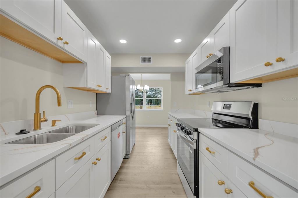 31201 Merry Road Tavares, FL 32778 - Photo 16 of 40 a kitchen with sink a stove and cabinets