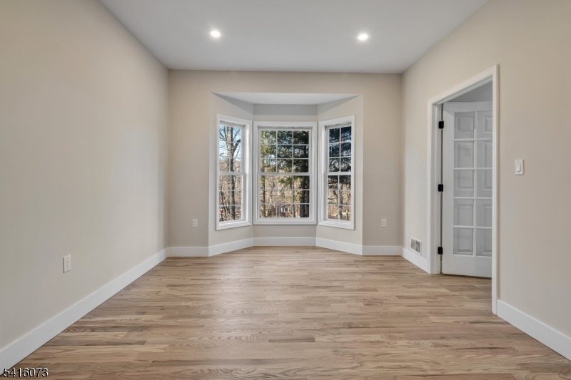139 Flanders Netcong Road Flanders, NJ 07836 - Photo 11 of 40 a view of an empty room with wooden floor and a window