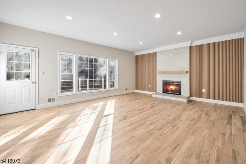 139 Flanders Netcong Road Flanders, NJ 07836 - Photo 13 of 40 an empty room with wooden floor fireplace and windows