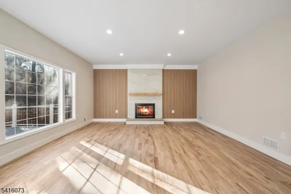 a view of an empty room with a window and a fireplace