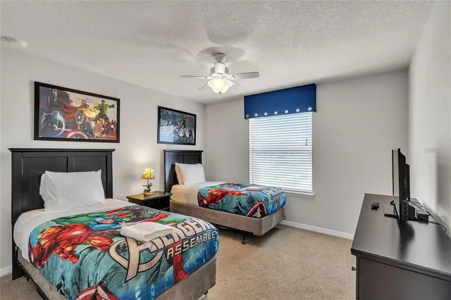 a bedroom with two beds and a chandelier