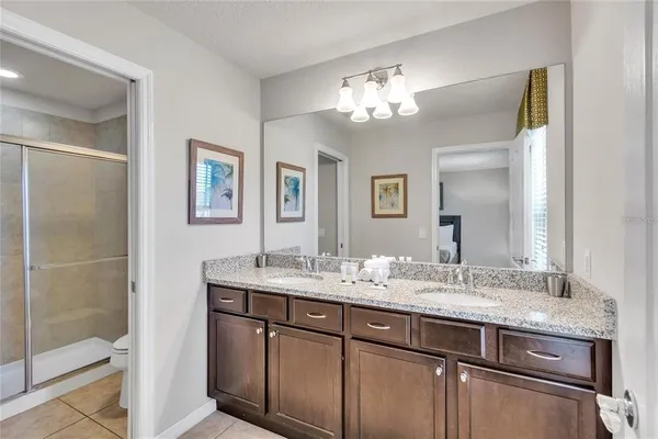 a bathroom with a granite countertop sink a mirror and a shower
