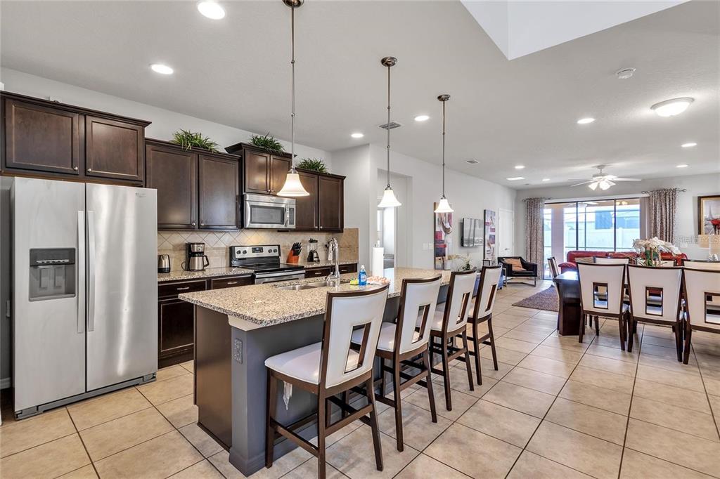 8916 Rhodes Street Kissimmee, FL 34747 - Photo 3 of 34 a large kitchen with a table and chairs