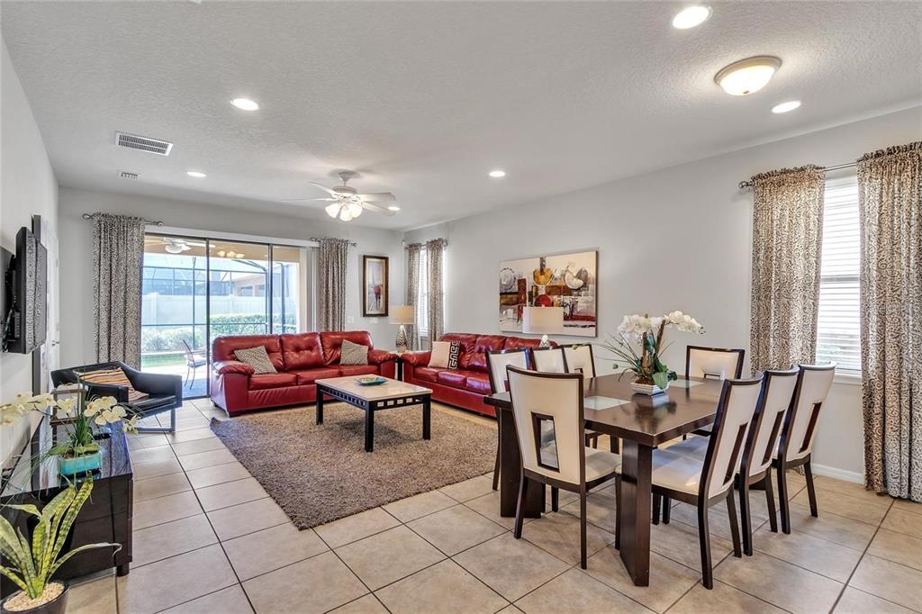 8916 Rhodes Street Kissimmee, FL 34747 - Photo 5 of 34 a living room with furniture a large window and a flat screen tv