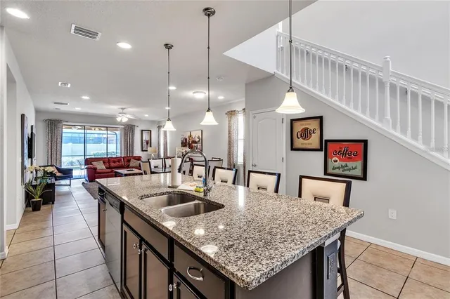 a kitchen with stainless steel appliances granite countertop a kitchen island a stove and a sink