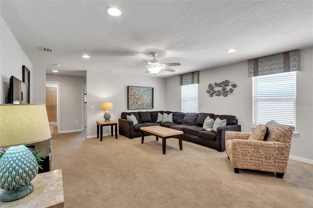 a living room with furniture and a ceiling fan