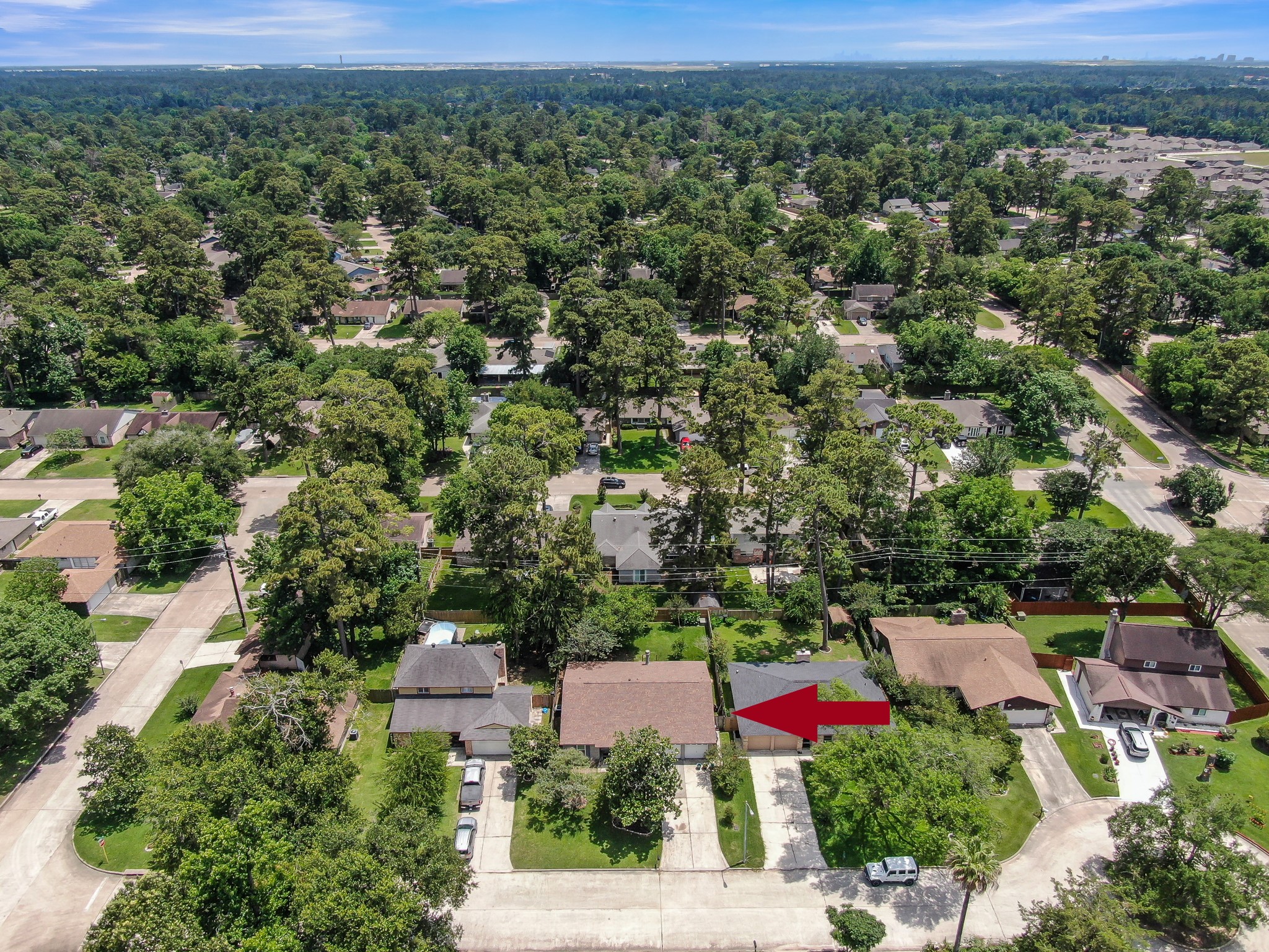 4314 Enchantedgate Drive Spring, TX 77373 - Photo 47 of 47 Aerial photo showcases a suburban neighborhood surrounded by lush greenery. The homes are well-spaced, with mature trees lining the streets, providing a serene and private atmosphere. The highlighted property appears to be a single-family home with a driveway, ideally situated in a peaceful, tree-filled area.