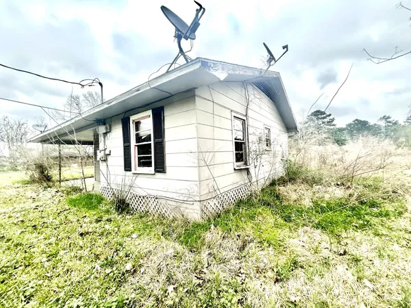 a view of a house with a small yard and wooden floor and fence