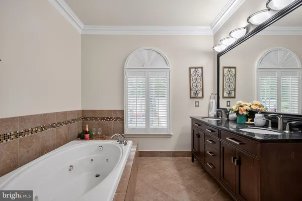 a view of a big room with windows and chandelier fan