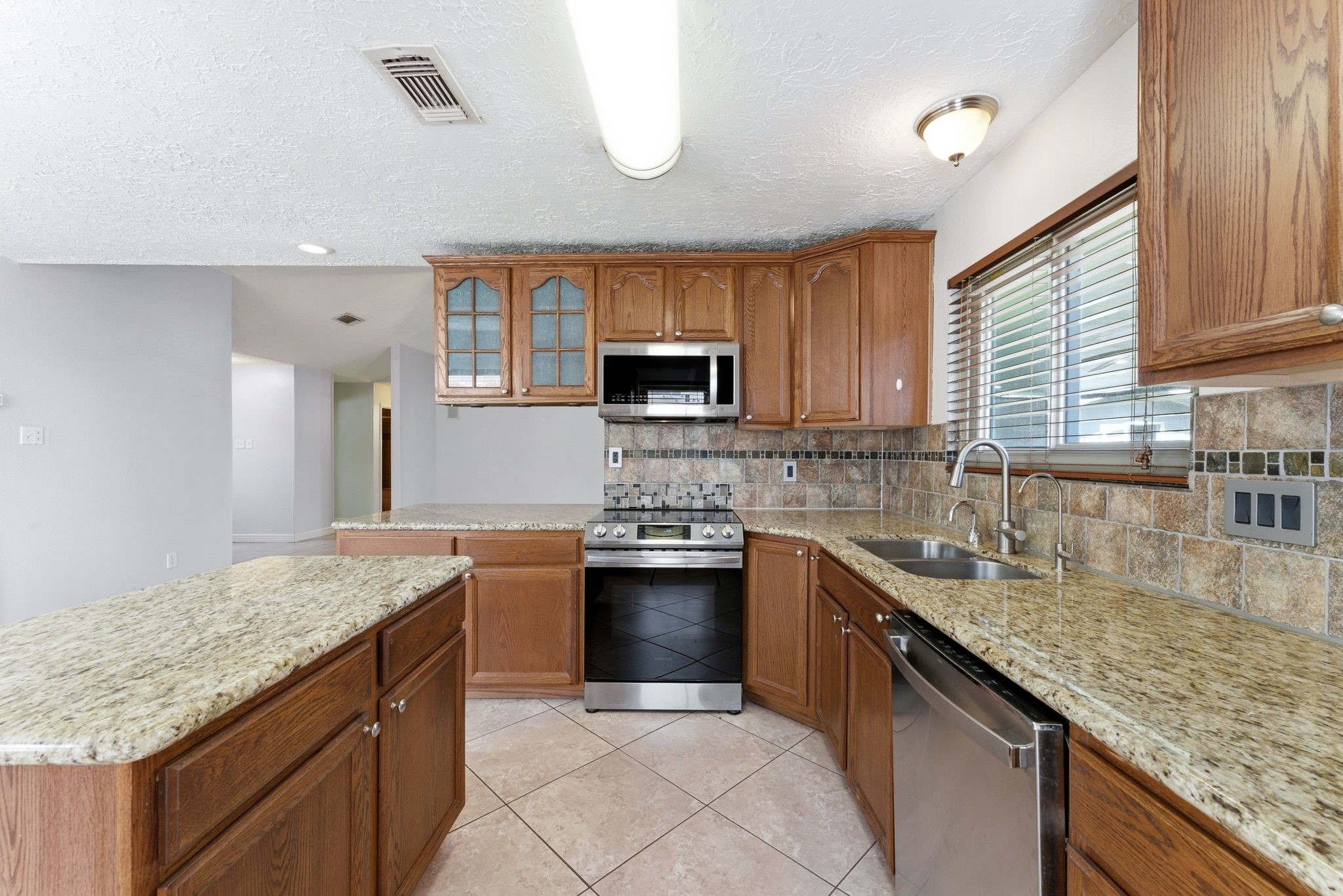 21514 Slippery Creek Lane Spring, TX 77388 - Photo 9 of 27 a kitchen with stainless steel appliances granite countertop a sink stove and oven