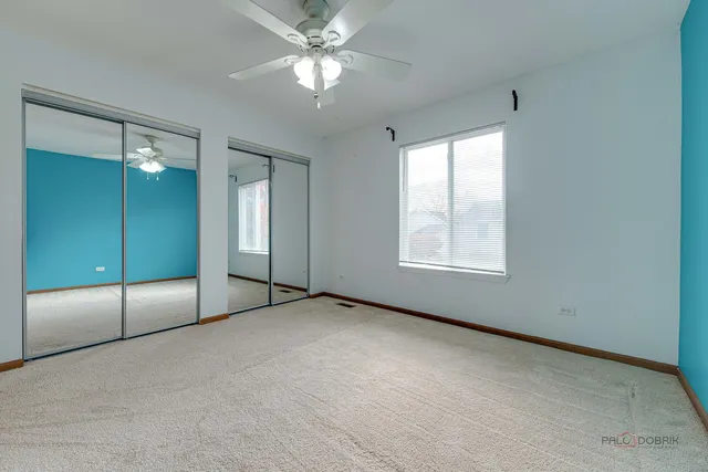 an empty room with fan and windows