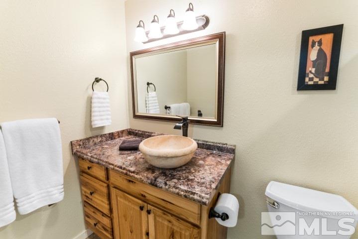 5155 Pasture View Road Reno, NV 89510 - Photo 12 of 21 a bathroom with a granite countertop toilet sink and mirror