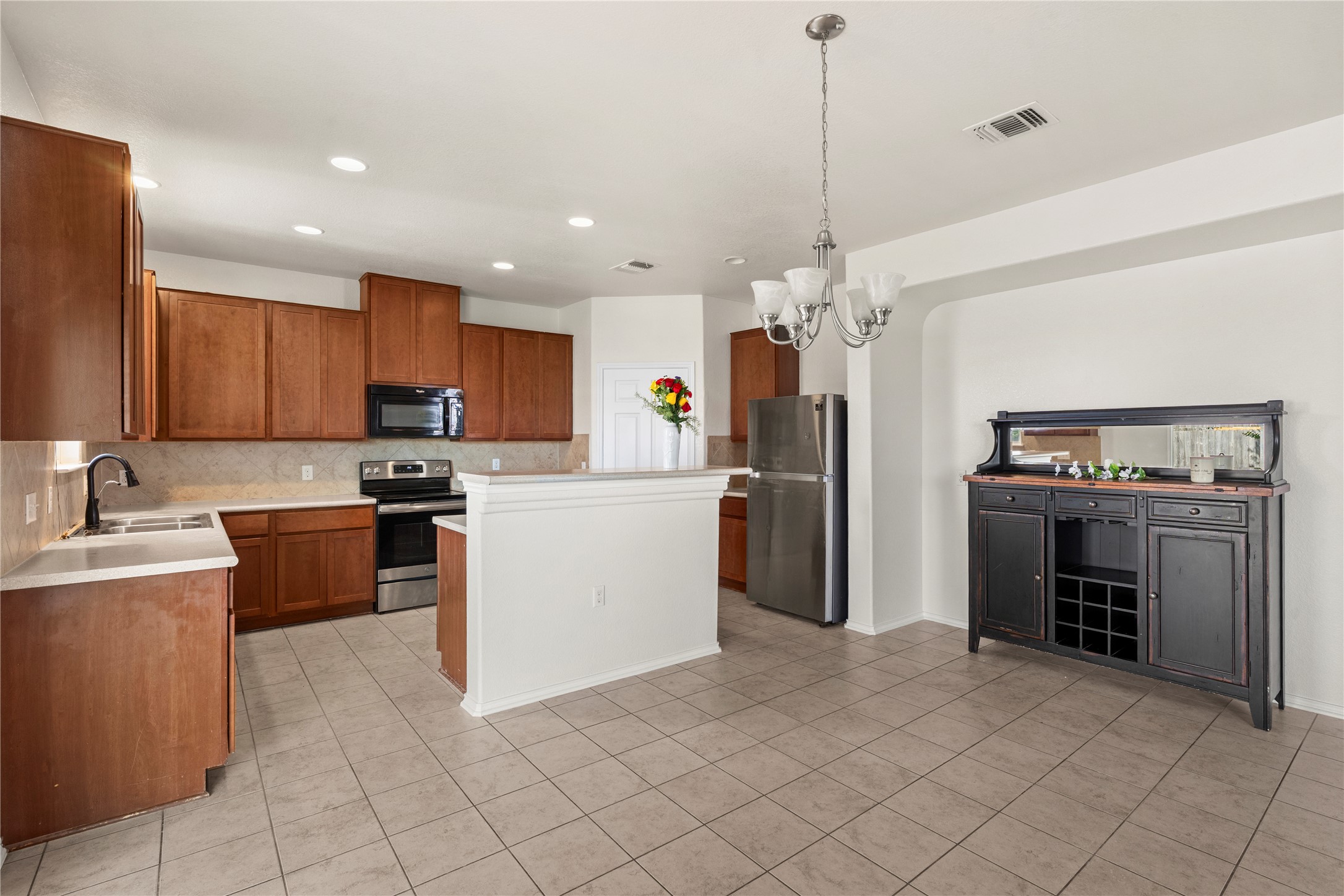 8613 Capitol View Drive Austin, TX 78747 - Photo 19 of 33 A streamlined kitchen and dining area features warm wood cabinetry and durable tile flooring.