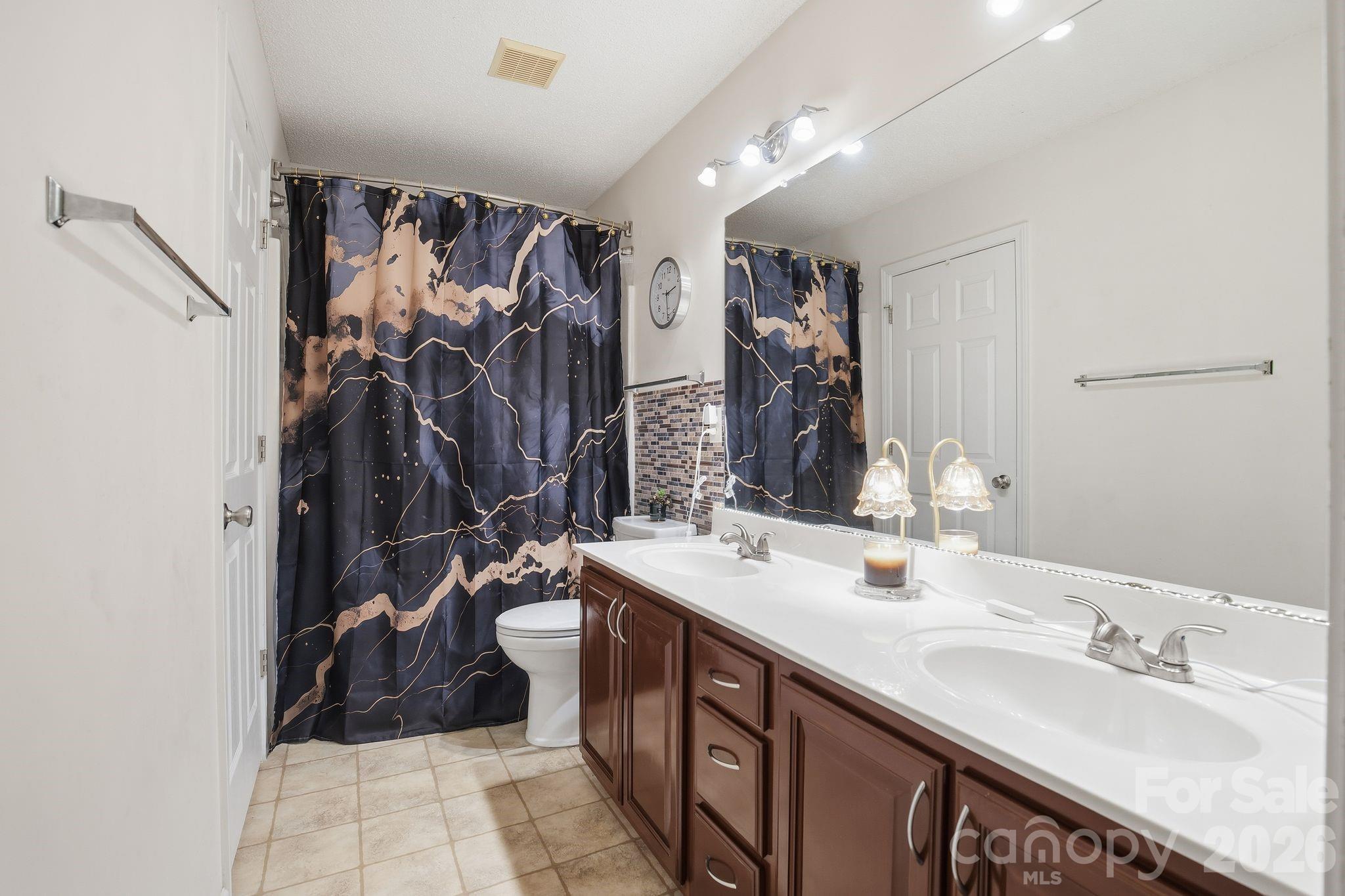 8376 Rudolph Road Charlotte, NC 28216 - Photo 14 of 28 a bathroom with double vanity and a mirror