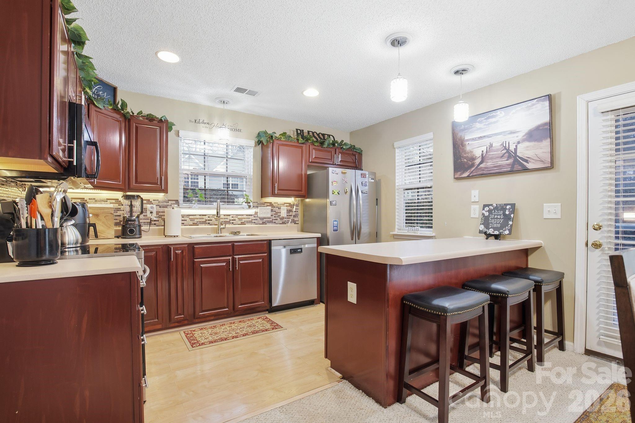 8376 Rudolph Road Charlotte, NC 28216 - Photo 16 of 28 a kitchen with kitchen island granite countertop a sink counter top space and cabinets