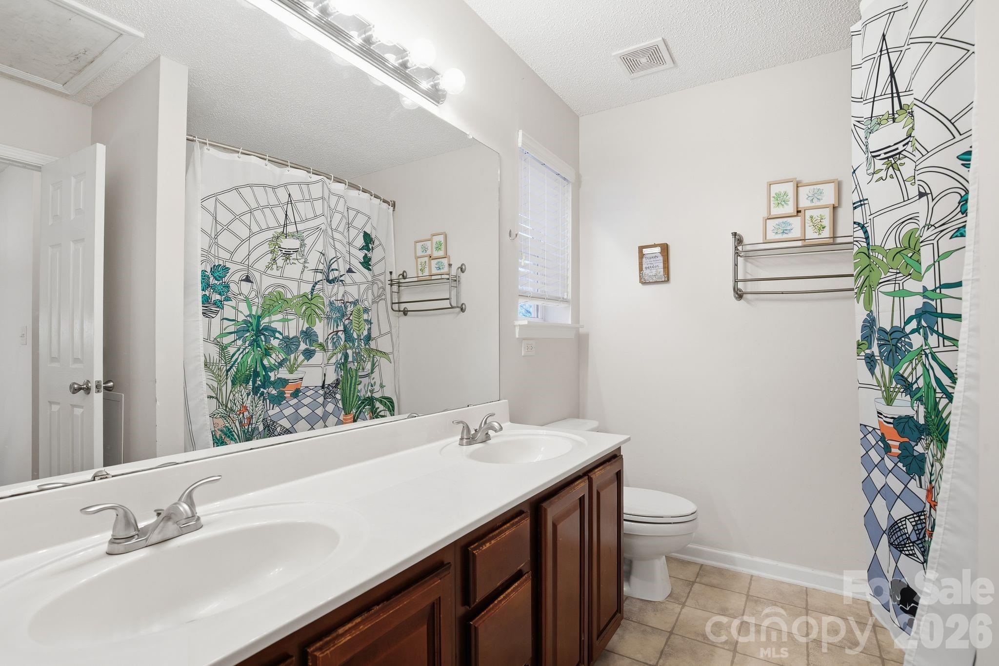 8376 Rudolph Road Charlotte, NC 28216 - Photo 22 of 28 a bathroom with a granite countertop sink and a toilet
