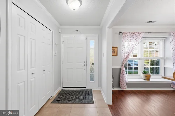 a view of a hallway with wooden floor and windows