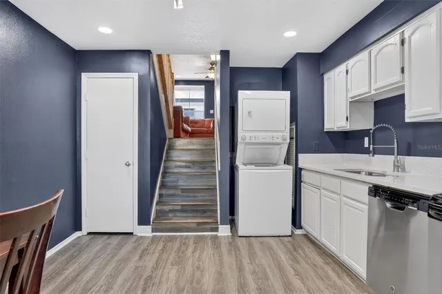 a kitchen with a sink a refrigerator and cabinets