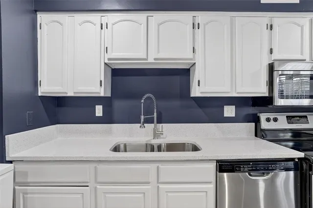 a kitchen with granite countertop white cabinets and sink