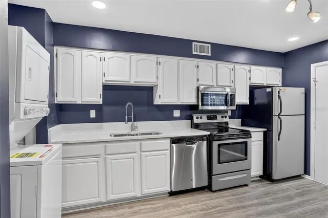 a kitchen with kitchen island a white cabinets and refrigerator