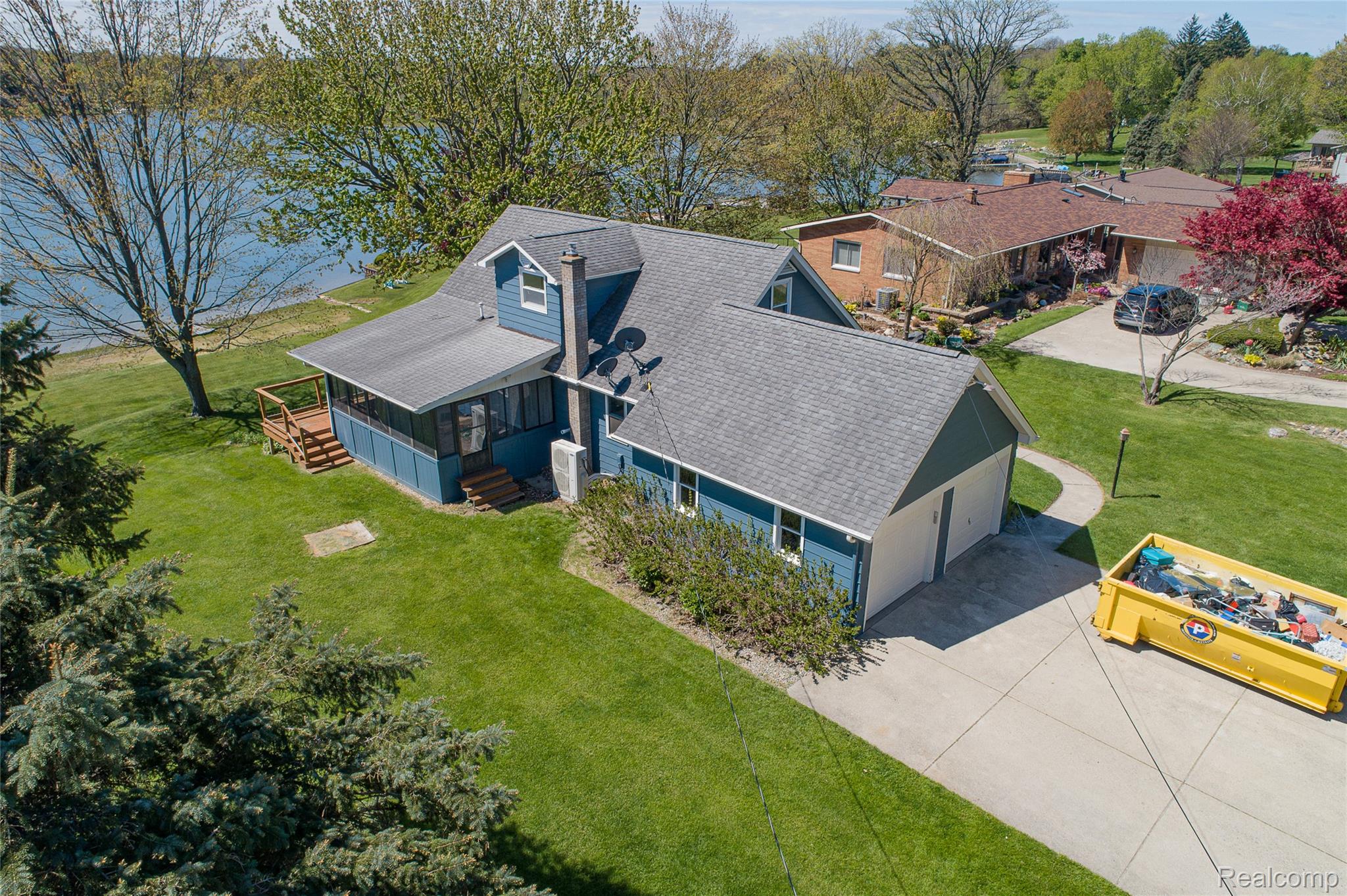 2855 Farmers Creek Road Metamora, MI 48455 - Photo 43 of 51 Waterfront property featuring a screened porch, attached two-car garage, expansive lawn, and mature trees
