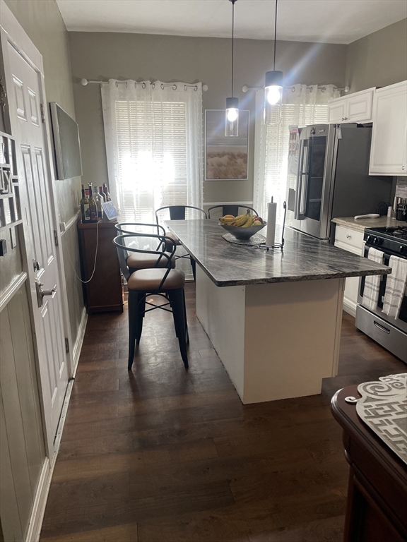 58 Brett Street, Unit 1 Brockton, MA 02301 - Photo 1 of 7 a kitchen with stainless steel appliances granite countertop a refrigerator a sink dishwasher a stove and a dining table with wooden floor