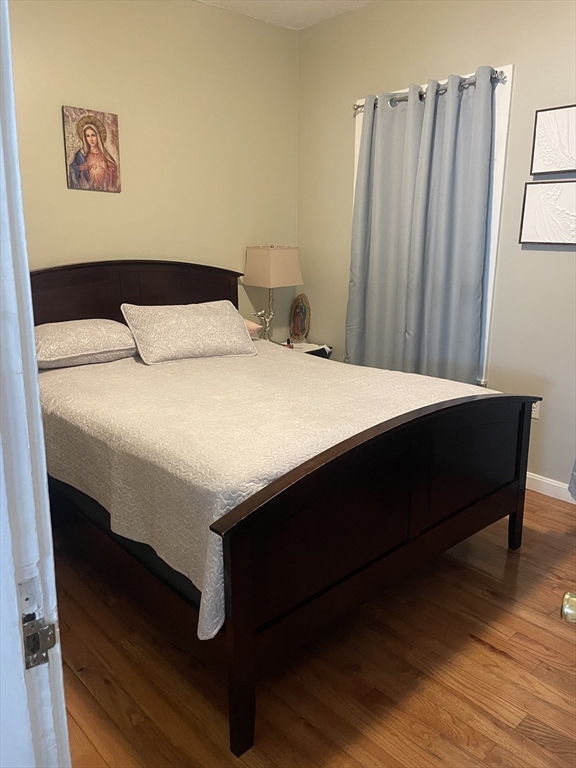 58 Brett Street, Unit 1 Brockton, MA 02301 - Photo 3 of 7 a bedroom with a bed and wooden floor