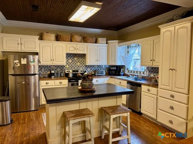 a kitchen with stainless steel appliances granite countertop a sink and a refrigerator