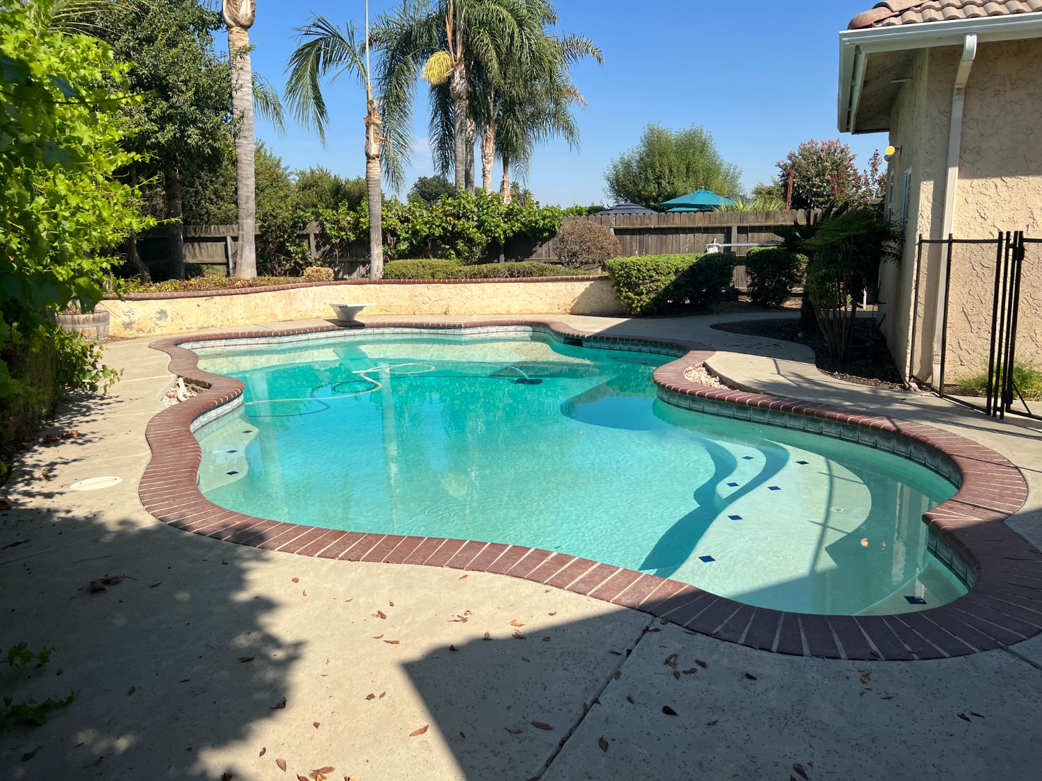 1046 Lords Court Lemoore, CA 93245 - Photo 23 of 23 a view of a swimming pool with a yard and plants
