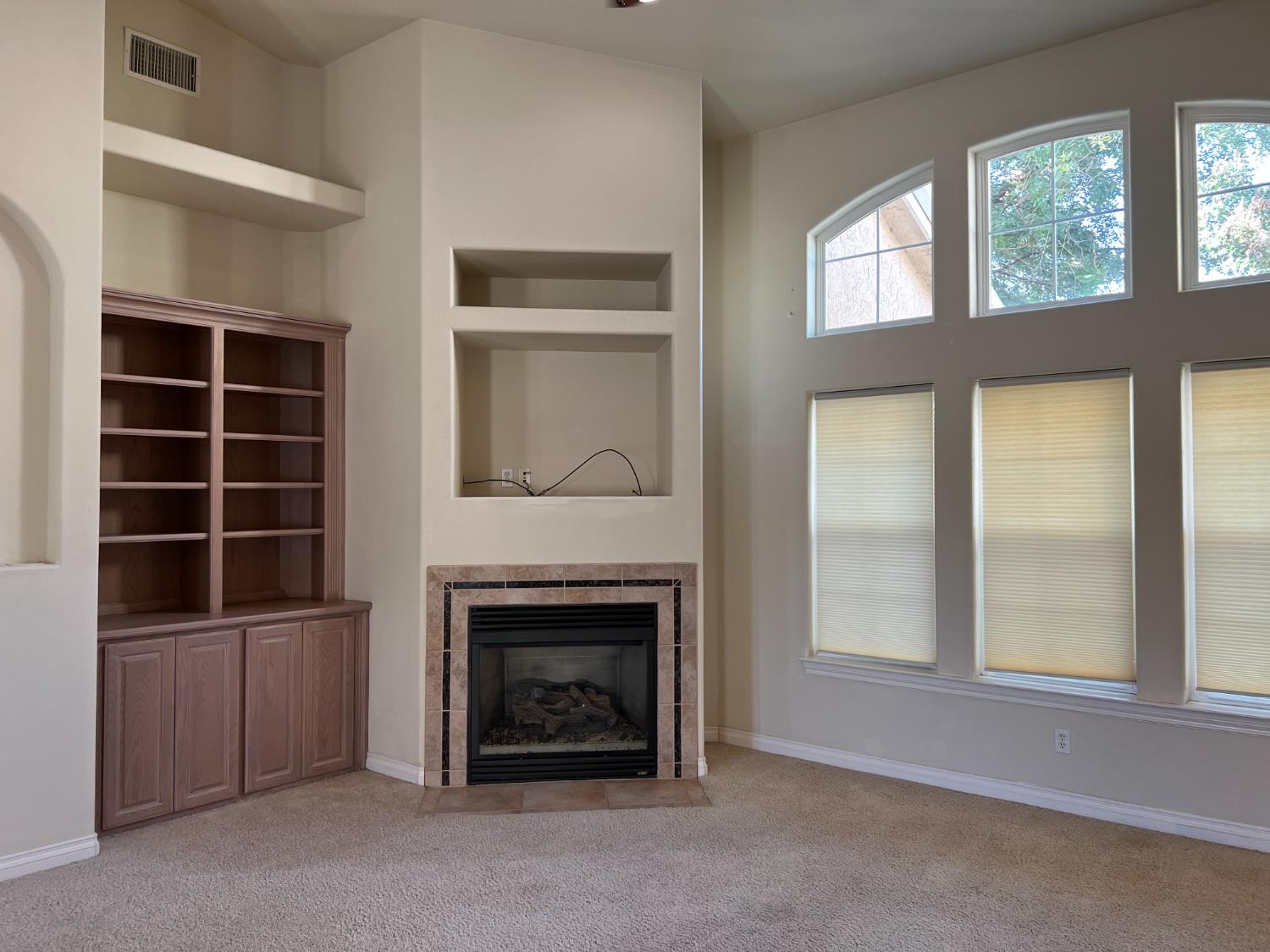1046 Lords Court Lemoore, CA 93245 - Photo 5 of 23 a living room with a fireplace and a window