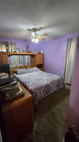a bedroom with a bed and painting on the wall