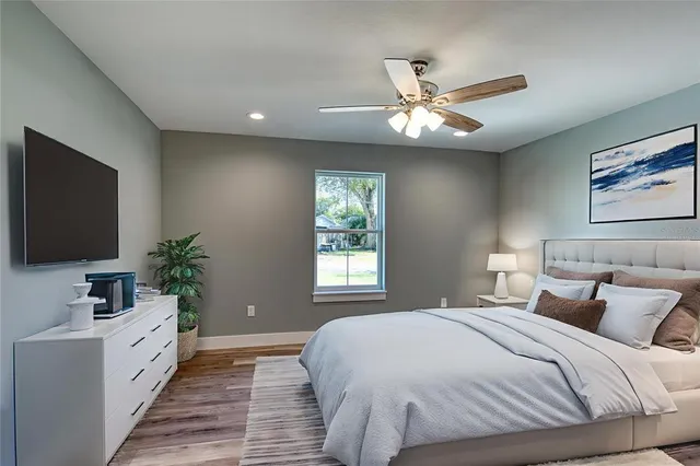 a spacious bedroom with a large bed and a flat screen tv