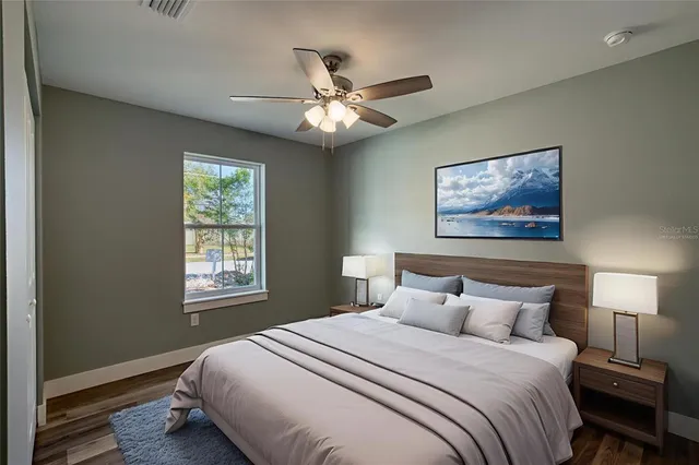 a bathroom with a granite countertop bathtub shower sink vanity mirror and toilet