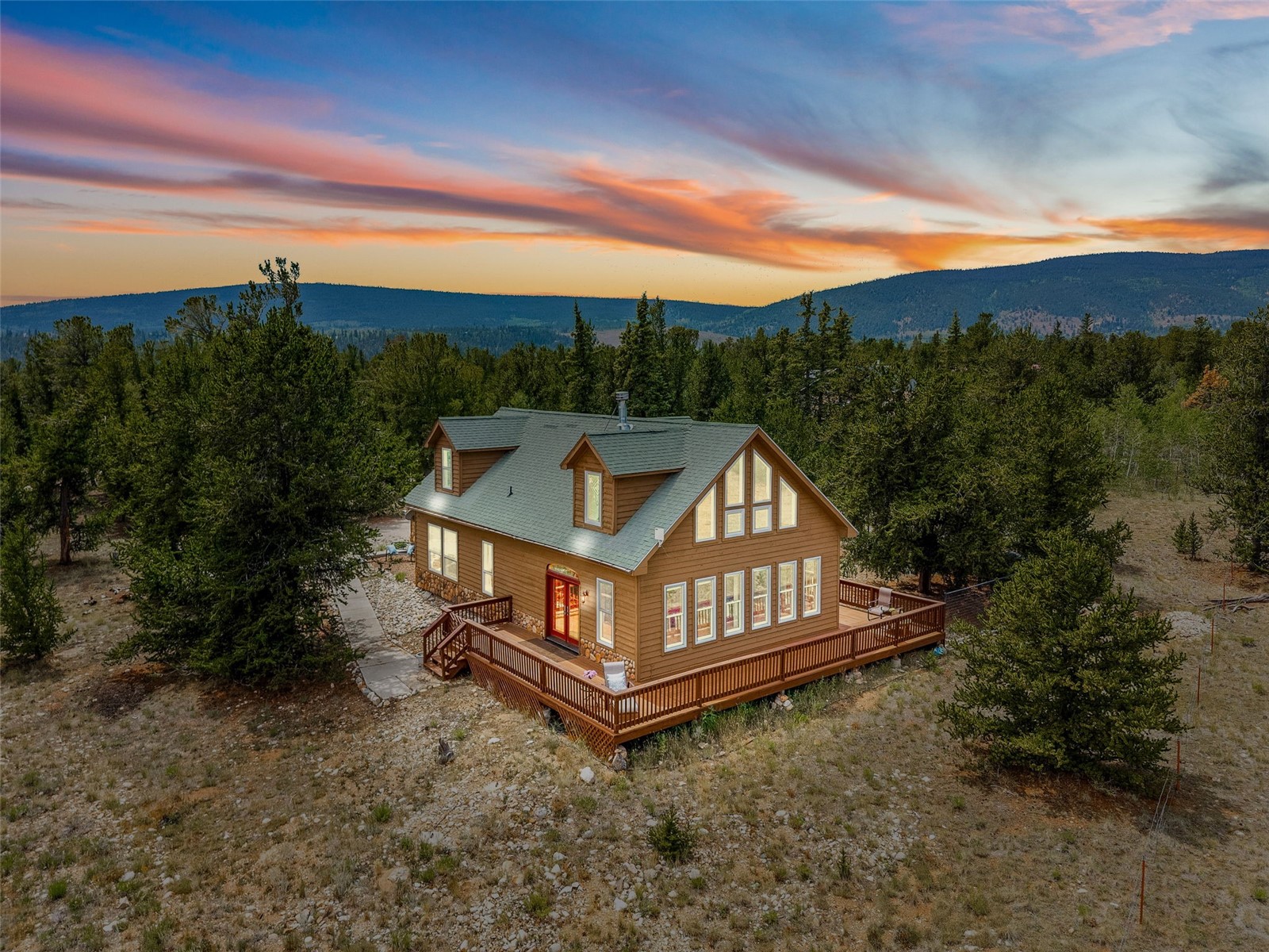a view of a white house with a yard and wooden fence