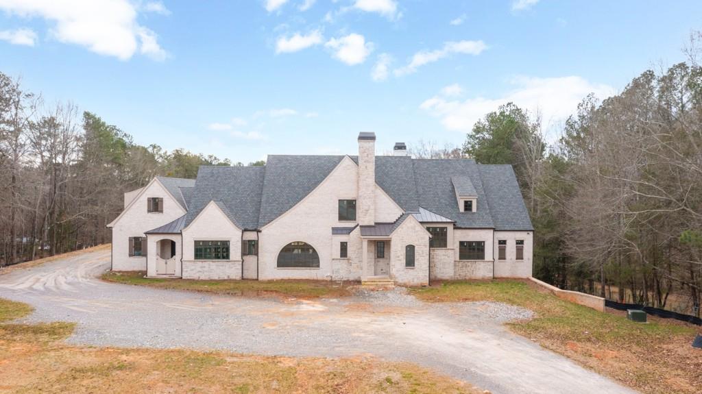 a view of a white house with a yard next to a road