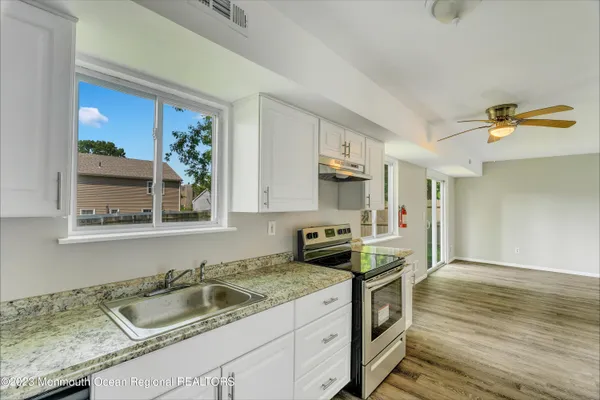 a bathroom with a granite countertop sink toilet and a mirror