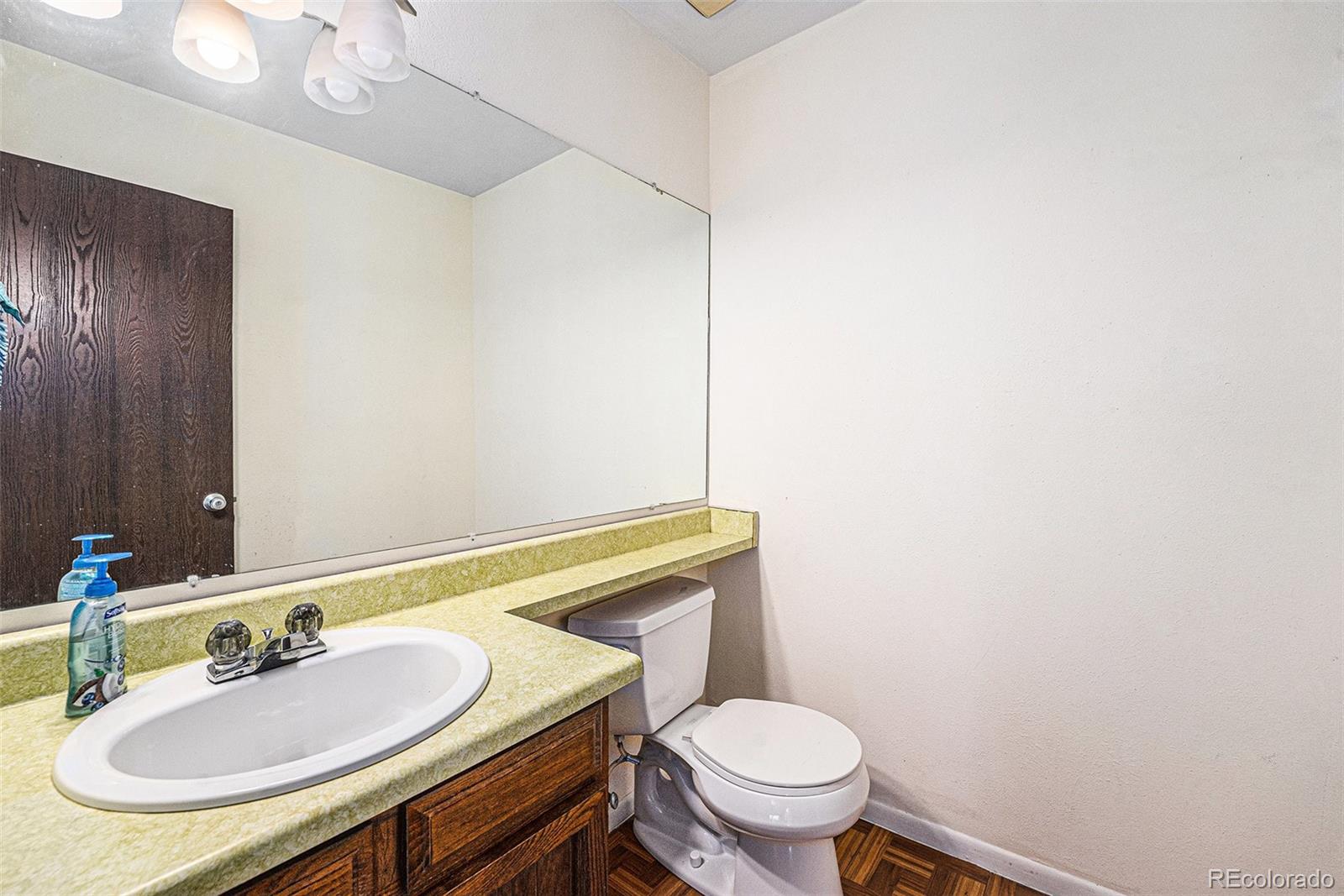 8746 Carr Loop Arvada, CO 80005 - Photo 12 of 22 a bathroom with a sink toilet and mirror