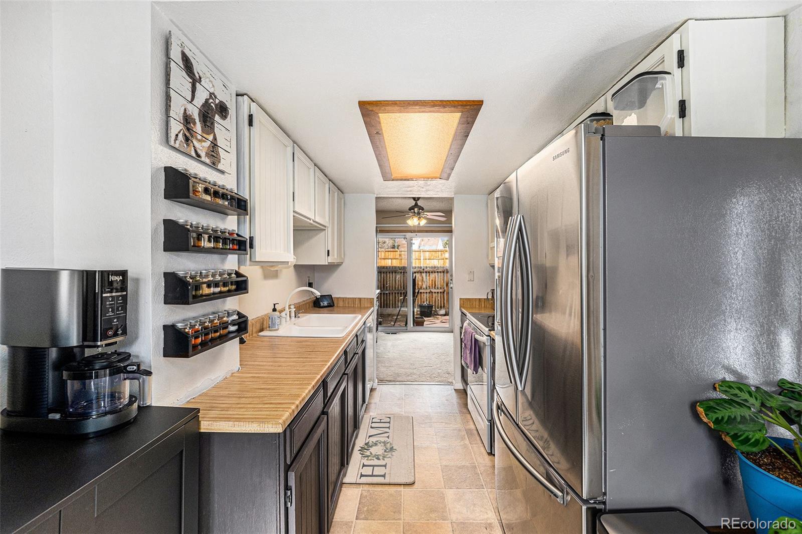 8746 Carr Loop Arvada, CO 80005 - Photo 3 of 22 a kitchen with stainless steel appliances granite countertop a refrigerator a stove and a sink with wooden floor