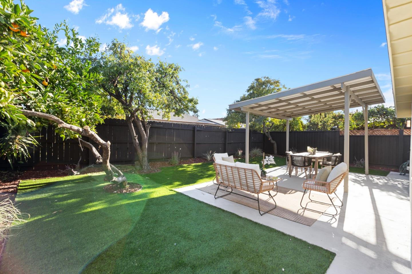 262 Checkers Drive San Jose, CA 95116 - Photo 15 of 17 a view of a backyard with table and chairs with wooden fence and plants
