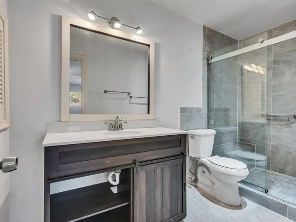 a bathroom with a sink a toilet and shower