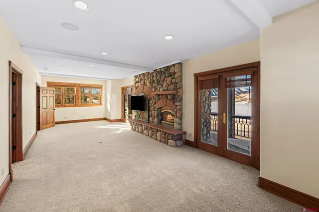 a view of an empty room with window and fireplace