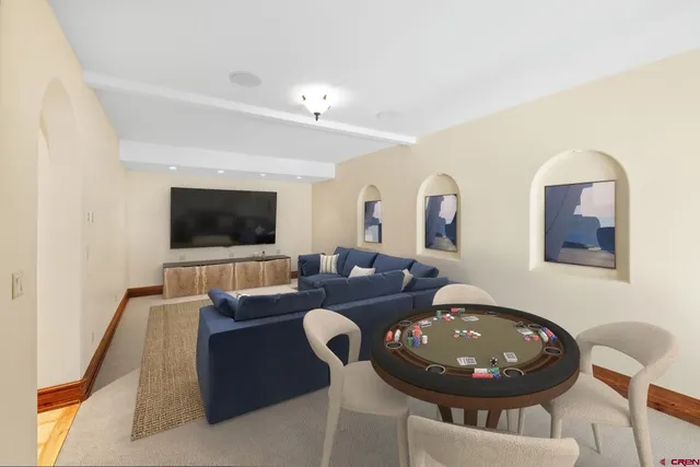 a living room with furniture a flat screen tv and kitchen view